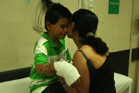 Bryan López, de 10 años, es consolado por su madre en emergencias del hospital Bloom por lesiones en su mano provocadas por un mortero la noche del 24 de diciembre. Foto Frederick Meza