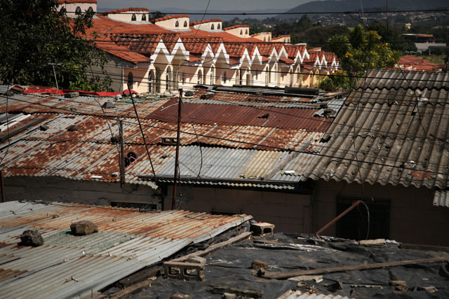 Los techos de las viviendas de la comunidad San Rafael, Santa Tecla, contrastan con los techos de los vecinos de la urbanización de clase media custodiada por vigilantes armados. El Faro publicó en 2012 el reportaje  gráfico 