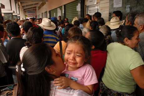 Ariana Pérez, de 4 años de edad, llora después de 9 horas de espera junto a su madre en la cola del duicentro de Santa Tecla el jueves 28 de enero. Foto Mauro Arias