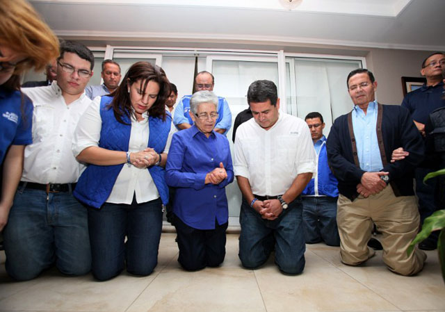 El ganador de las elecciones en Honduras, Juan Orlando Hernández (al centro) del  Partido Nacional reza junto a su familia mientras espera los resultados de las elecciones en Tegucigalpa, el 24 de noviembre de 2013. Foto AFP