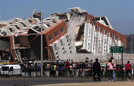 Residentes observan un edificio desplomado en Concepcion, Chile.