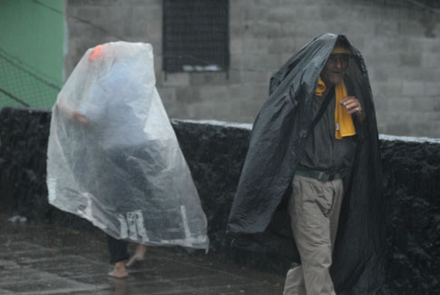 Ancianos se protegen de la lluvia en la comunidad Tutunichiapa I de San Salvador. Foto Mauro Arias