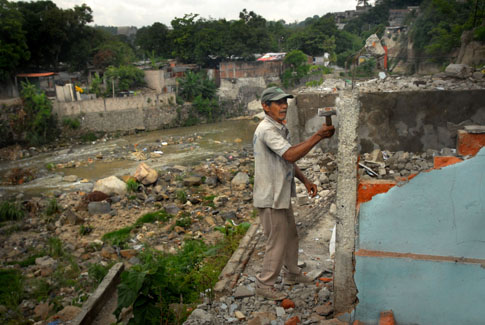 José Isabel Meléndez demoliendo casas abandonadas por sus habitantes después de la crecida del Acelhuate durante la tormenta Ida.