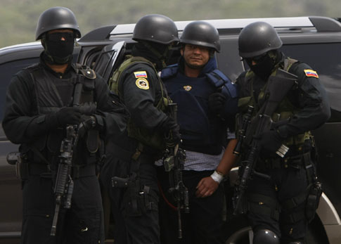 El salvadoreño Francisco Chávez Abarca, centro, es escoltado por agentes de la policía secreta venezolana en el aeropuerto Simón Bolívar de Caracas para ser deportado a Cuba el miércoles 7 de julio de 2010.  Cuba lo acusa de haber realizado actos de terrorismo en la isla.