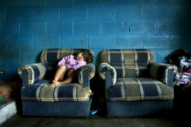 Saraí Montoya, hija de Karen Yamileth Cordero, duerme en un sillon después de haber estado jugando con su hermano Ade en el pasaje de su casa.