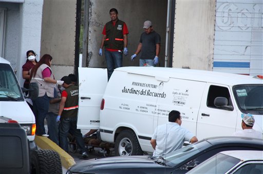 Forenses trasladan los cadáveres de por lo menos 59 personas que se hallaron en fosas en el estado de Tamaulipas. Foto Ap