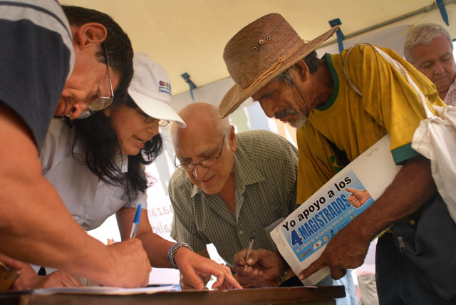 Víctor Hernández, campesino de Santo Tomás, firma al mismo tiempo que el ex presidente de la Corte Suprema Domingo Méndez la solicitud que el movimiento de 35 organizaciones cívicas presentará a la Asamblea Legislativa para que derogue el decreto que emitió el pasado jueves contra la Sala de lo Constitucional. Hernández llegó a la plaza del Salvador del Mundo para apoyar a los 4 magistrados porque dice que no quiere que sus nietos un día le vayan a reclamar que no hizo nada contra las injusticias en este país. La recolección de firmas seguirá este día a partir de las 4 p.m. en el mismo lugar.