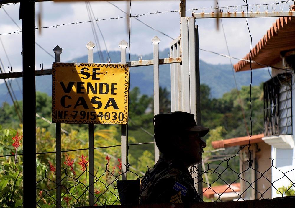 Un soldado pasa frente una casa en venta en el reparto La Campanera de Soyapango. En esta comunidad, un significativo porcentaje de casas está en abandono. Foto Roberto Valencia.
