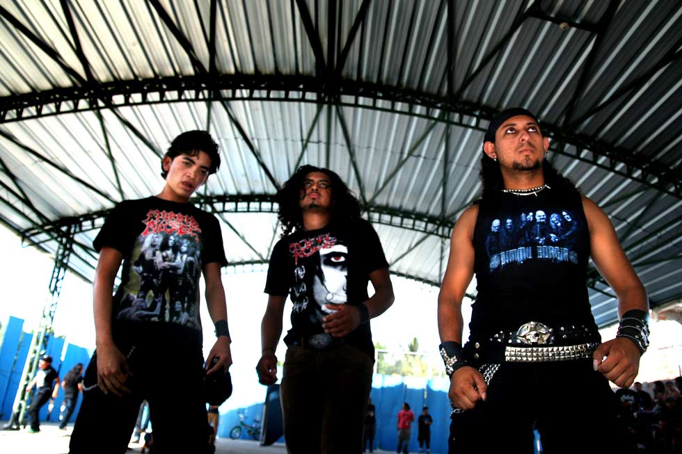 Tres jóvenes esperan iniciar un mosh en un concierto en San Rafael Cedros. El mosh es el ritual de prioridad del metal.