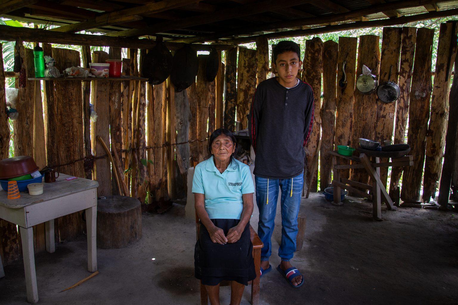 Felicita and her grandson pose in their kitchen. Felicita took responsibility for her grandson when her daughter, his mother, died. Now they depend on the help that comes from another one of her daughters who lives in Tegucigalpa, but who has been suspended from her job during the pandemic. Opatoro, August 8 2020. Photo: Martín Cálix