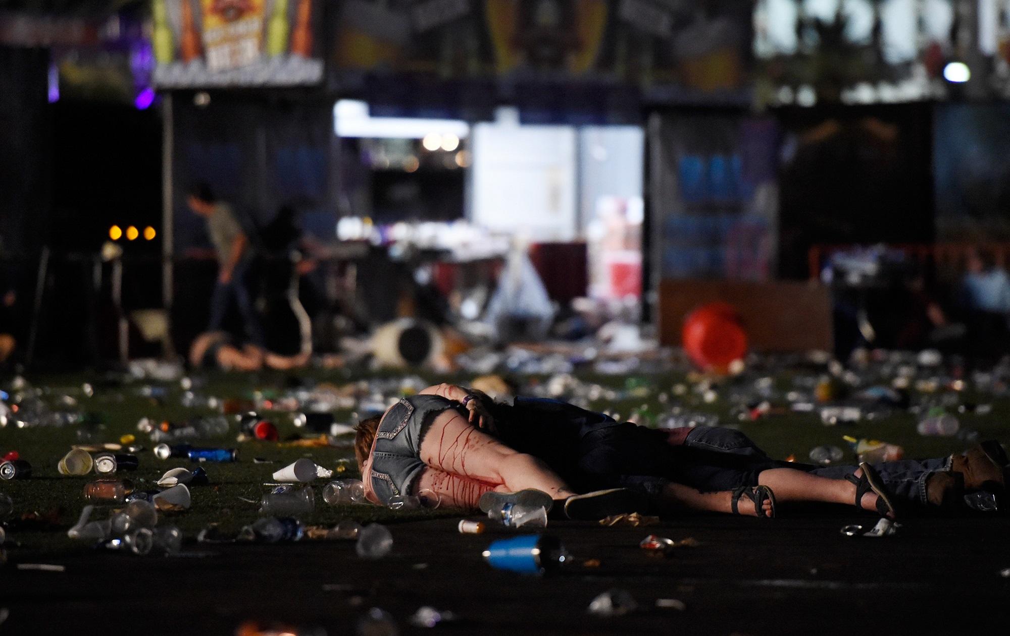 Tres personas permanecen inertes en el lugar en el que se celebraba el concierto de música country sobre el que disparó Stephen Paddock, un hombre blanco de 64 años que mató a no menos de 59 personas la noche del 1 de octubre de 2017 en Las Vegas, Nevada. Foto David Becker (AFP).