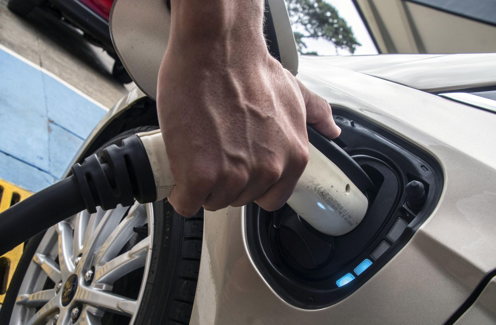 El costarricense Roberto Quirós, propietario de dos carros eléctricos, recarga su vehículo en una de las estaciones de servicio que brinda ese servicio en San José. Foto Ezequiel Becerra (AFP).