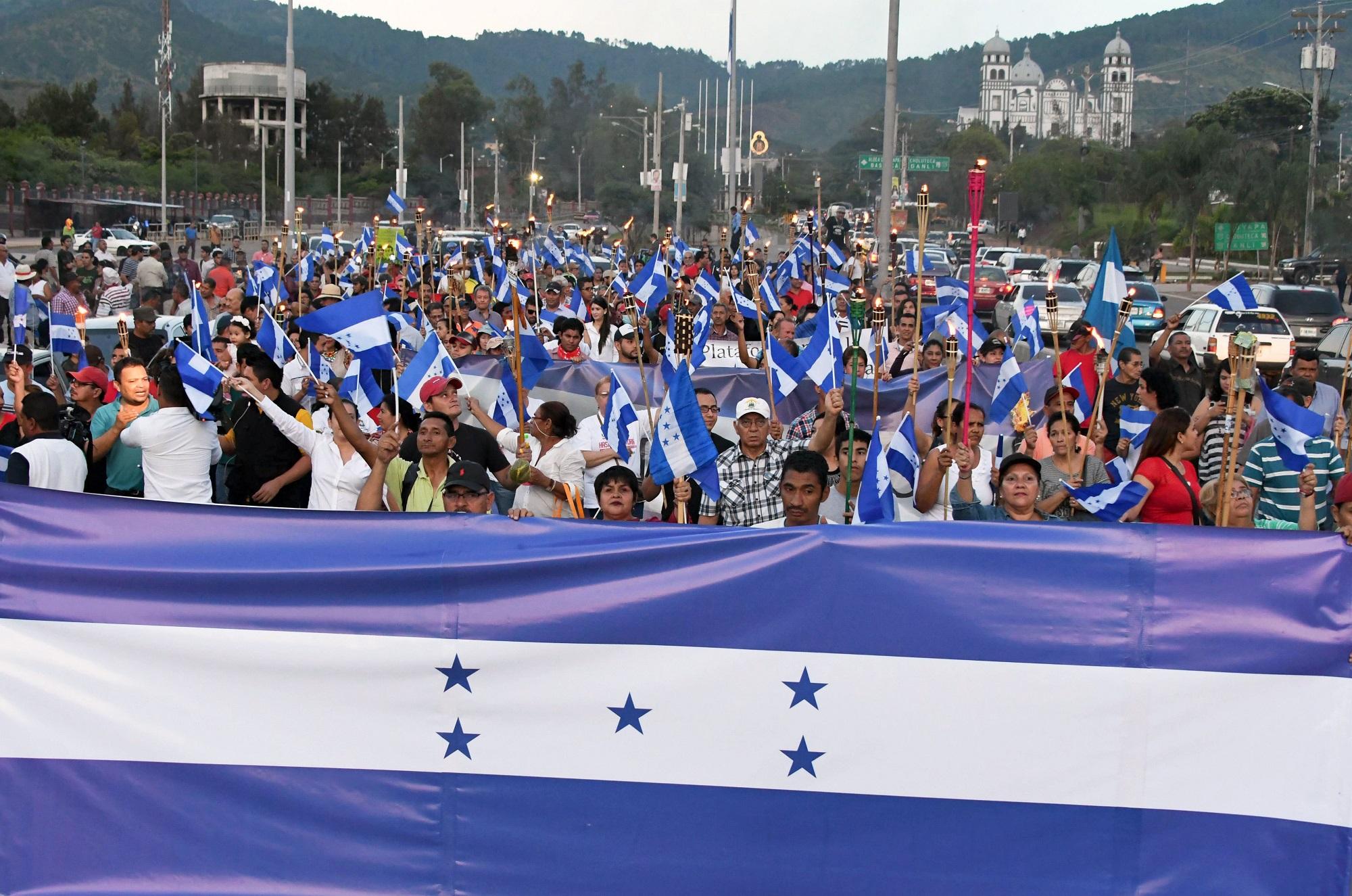 Hondureños marchan contra el polémico fallo de la Sala de lo Constitucional local que avaló que el actual presidente de la República, Juan Orlando Hernández, pueda optar a la reelección, algo que la Carta Magna prohíbe. Foto Orlando Sierra (AFP).