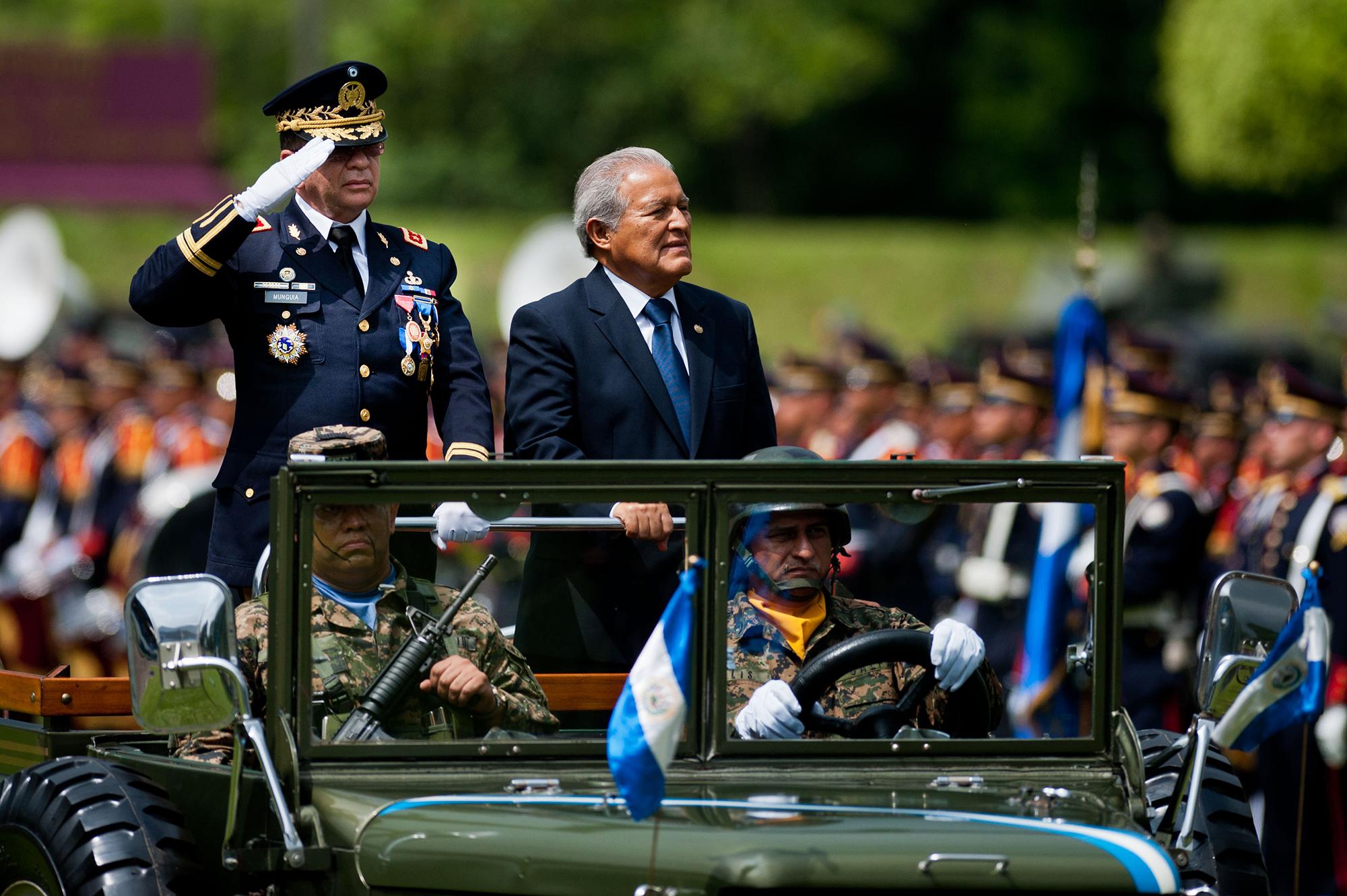 El presidente de El Salvador, Salvador Sánchez Cerén, y el ministro de Defensa, David Munguía Payés, en la ceremonia de revisión de tropas para para presentar al nuevo comandante general de las Fuerzas Armadas, el 5 de junio de 2014. Según los documentos de El Faro, ambos recibían un sobresueldo de $10,000 durante el primer gobierno del FMLN. Foto de AFP: José Cabezas.