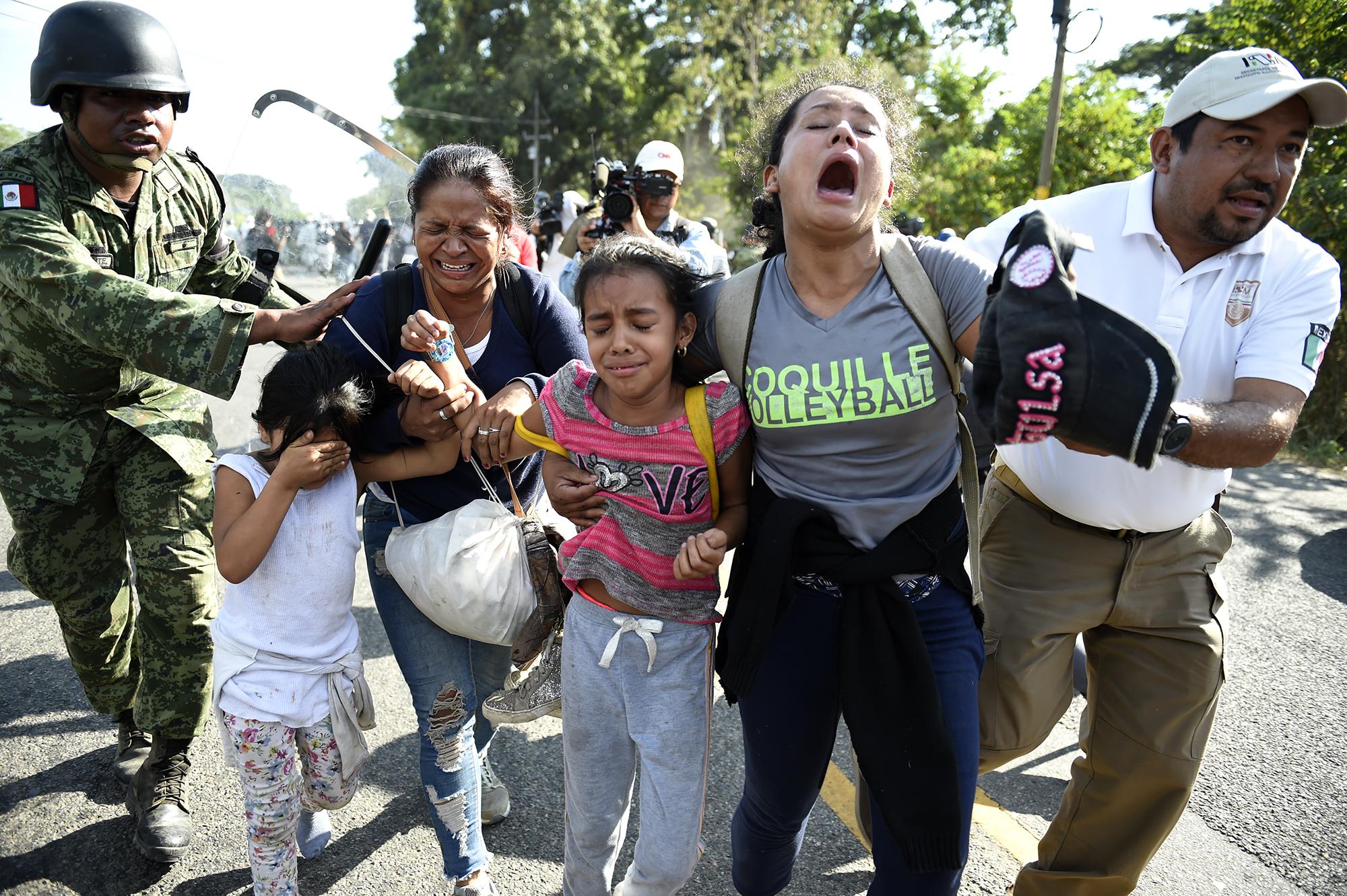 Miembros de la Guardia Nacional de México y oficiales del Instituto Nacional de Migración detienen a migrantes centroamericanos en Ciudad Hidalgo, Chiapas. A diferencia de lo ocurrido la semana pasada con otra caravana, en esta ocasión, la multitud encontró un punto donde cruzar la frontera sin oposición de las autoridades. El Gobierno envió cientos de agentes de seguridad para cazar a los migrantes antes de que llegaran a Tapachula, donde alrededor de 50,000 indocumentados se agrupan desde hace meses a la espera de seguir su viaje hacia el norte. Foto de AFP: Alfredo Estrella.