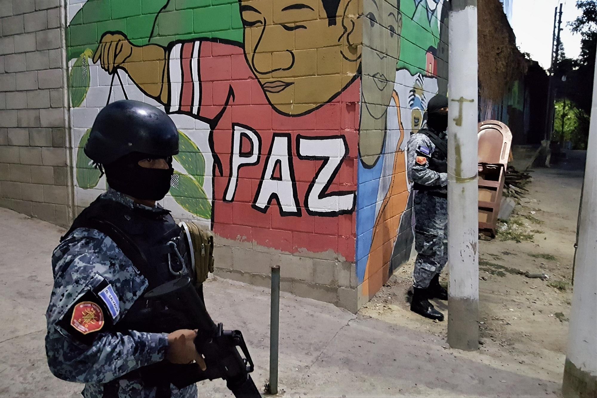 Dos miembros de la Sección Táctica Operativa de la PNC custodian el portón de ingreso a la comunidad Colfer, en el barrio San Jacinto de San Salvador. Si se mantuviera la tendencia, el país terminaría el año 2019 con una tasa de 45 homicidios por cada 100 000 habitantes. Foto Roberto Valencia (El Faro).