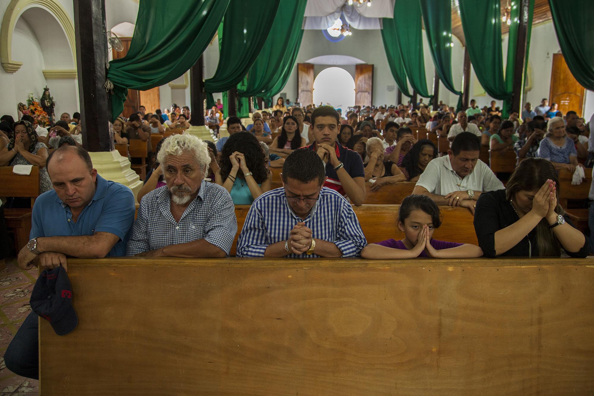 El diputado Reynaldo Cardoza junto a los alcaldes Milton Serrano y Emilio Ortiz, de los municipio s de San Miguel de Mercedes y El Paraíso, respectivamente, rezan con la hija y la esposa del político. Cardoza convocó a una misa el pasado domingo 26 de febrero, en la cual pidió a Dios que ilumine a los magistrados de la Cámara Segunda de lo Civil, donde se le procesa a él y a su cónyuge por enriquecimiento ilícito./ Foto: Víctor Peña