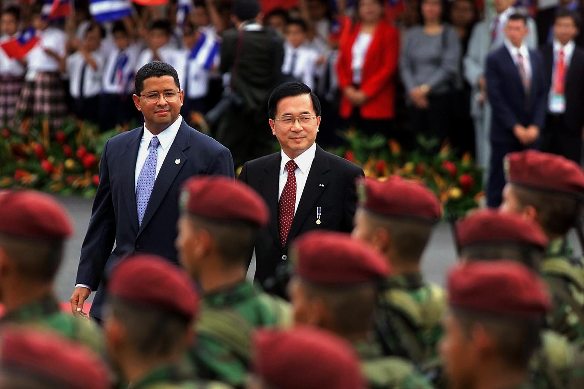 El presidente taiwanés Chen Shui-bian (C) y su homólogo salvadoreño Francisco Flores (L) revisan una guardia de honor el 23 de mayo de 2001 en una ceremonia de bienvenida en el Aeropuerto Internacional de Comalapa en El Salvador./ Foto AFP: Yuri Cortez