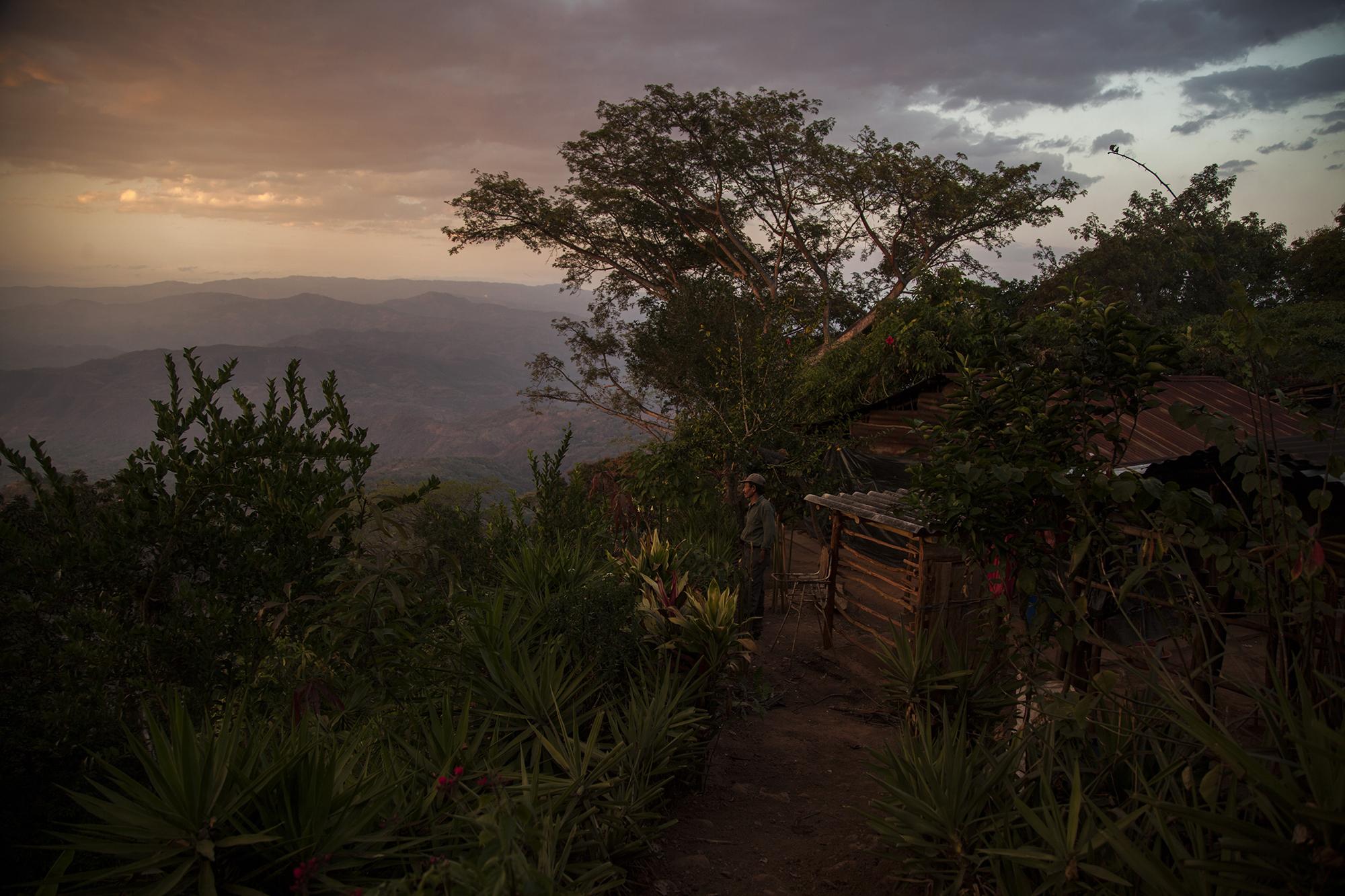 Desde su vivienda en lo alto de la montaña, José León Hernández disfruta del paisaje al atardecer. La comunidad ha gestionado el servicio de electricidad y hay ya un convenio firmado entre la alcaldía de Gualococti y el FISDL el 21 de junio de 2016. El costo del proyecto se estima en 130 mil dólares, y está en revisión para ser aprobado. En el caserío viven 168 personas: 47 mujeres, 42 hombres y 79 menores de edad.