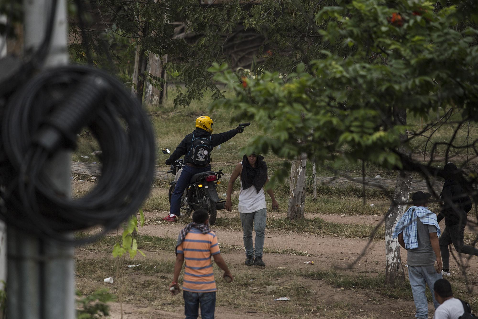 A la 1:00 p.m., uno de los manifestantes, que se conducía en una motocicleta sin placas, disparó varias veces contra una columna de policías que resguardaban las instalaciones del Infop. Otro grupo de manifestantes lo detuvo cuando intentaba huir, pero un sujeto intervino para que lo dejaran escapar. 