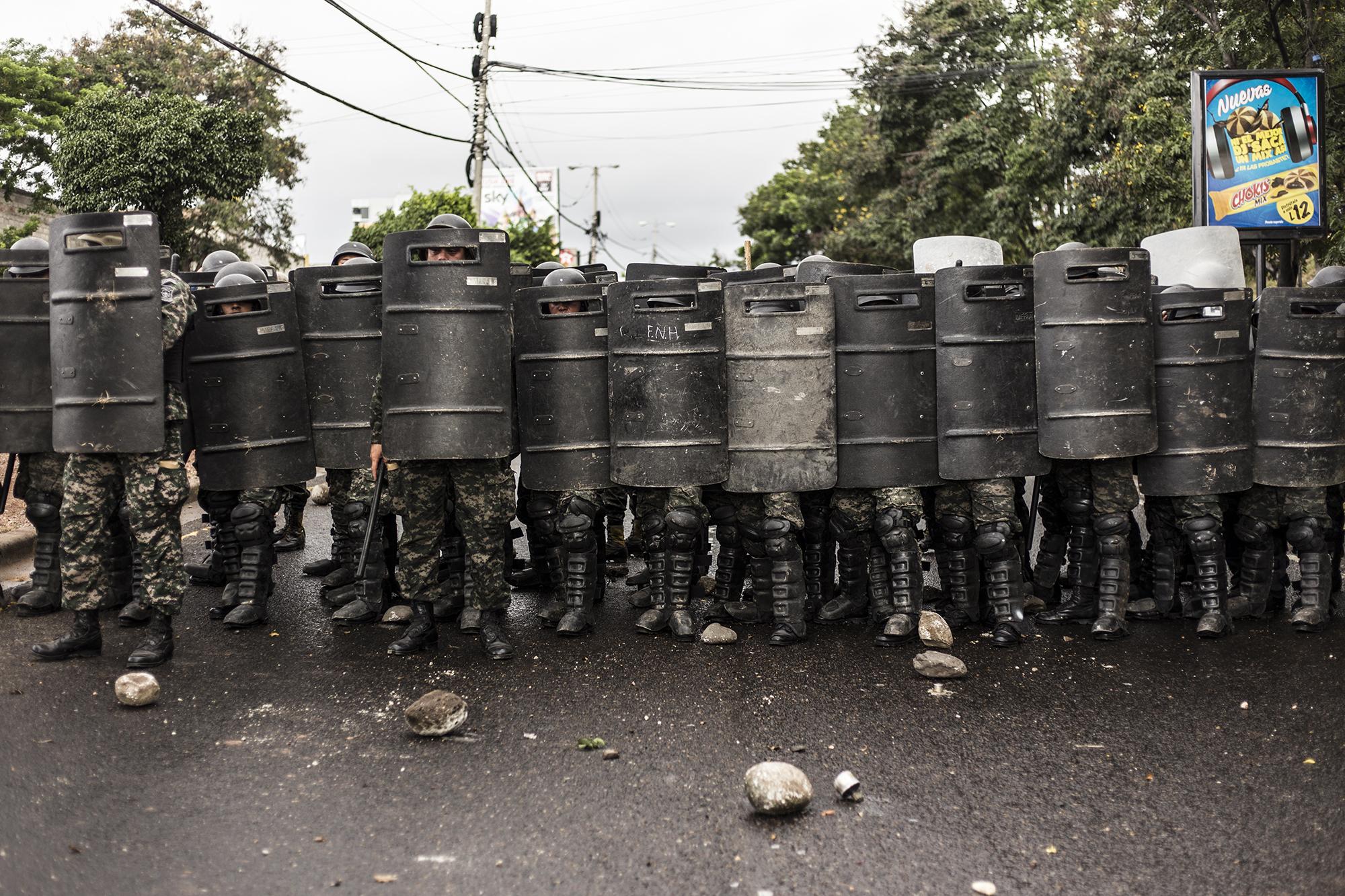 Militares se protegen de las piedras lanzadas por los manifestantes durante las protestas del jueves 30 de noviembre. Foto: Fred Ramos