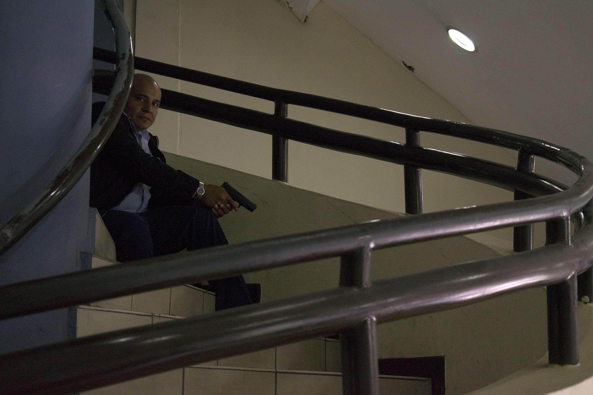 Un guardia de seguridad armado en la entrada principal de la Asamblea Legislativa, durante los disturbios del dia 14 de junio de 2018. Foto: Oscar Rivera / AFP 