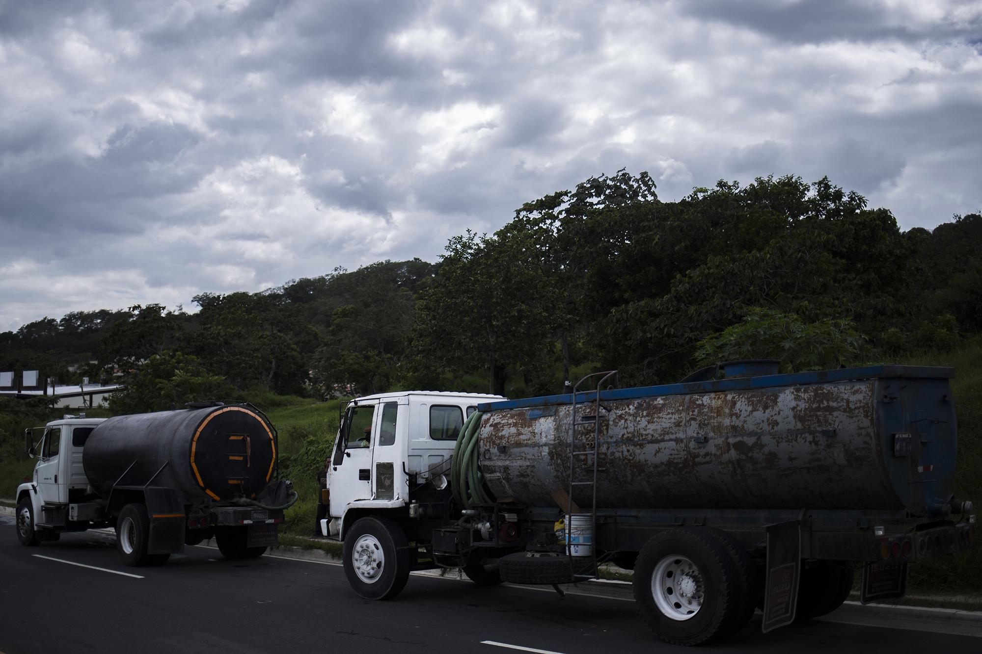 Pipas que abastecen a hoteles y colonia privadas, esperan para llenar su tanque, sobre el bulevar Cuscatlán, en el municipio de NuevoCuscatlán, La Libertad. Los camiones privados se abastecen de un pozo de agua potable, propiedad de la Alcaldía de Nuevo Cuscatlán. Foto de El Faro, por Víctor Peña.