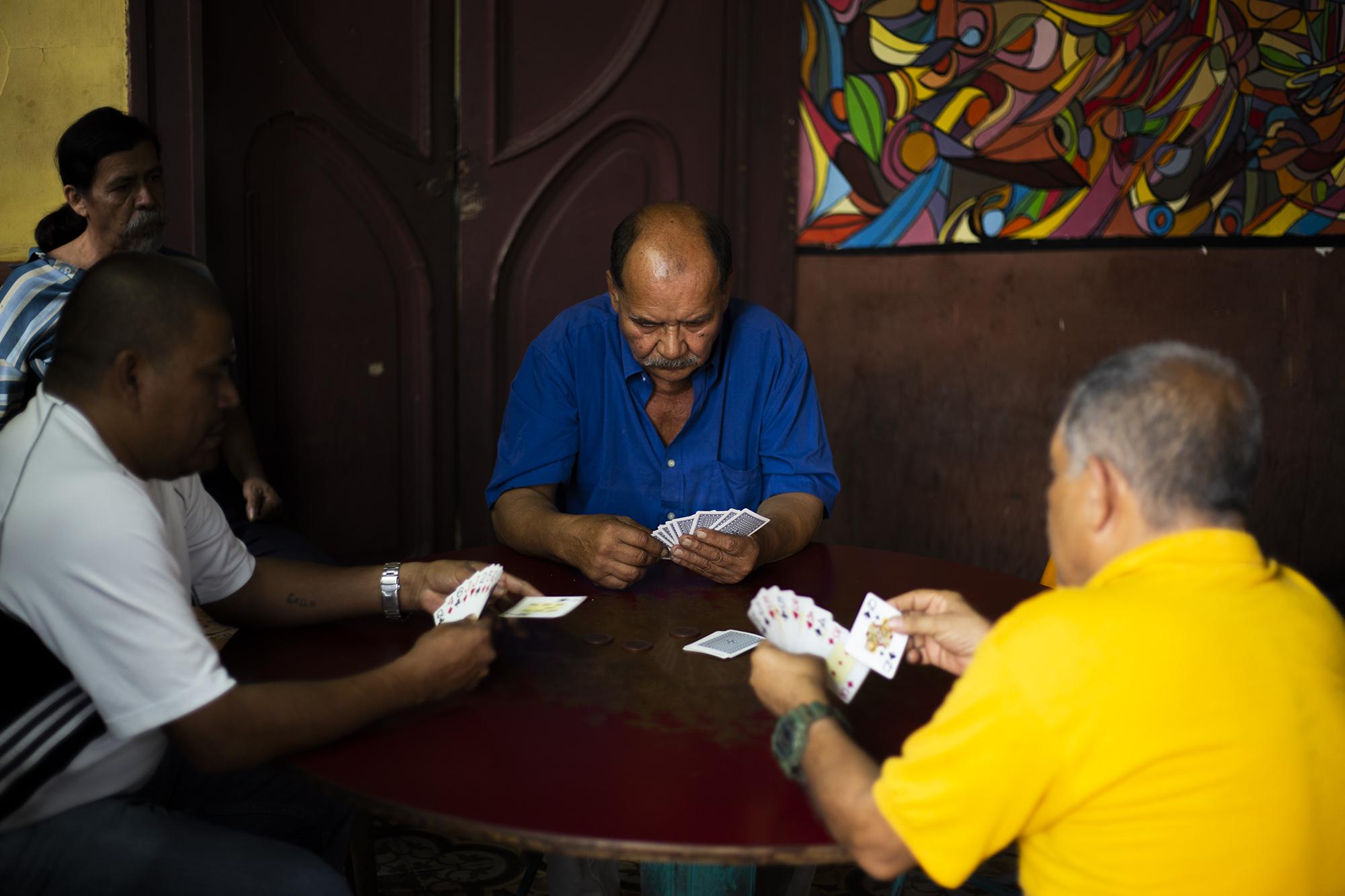 Un grupo de hombres juega cartas en La Dalia. A muchos de ellos no les gusta hablar con extraños y menos decir sus nombres, 