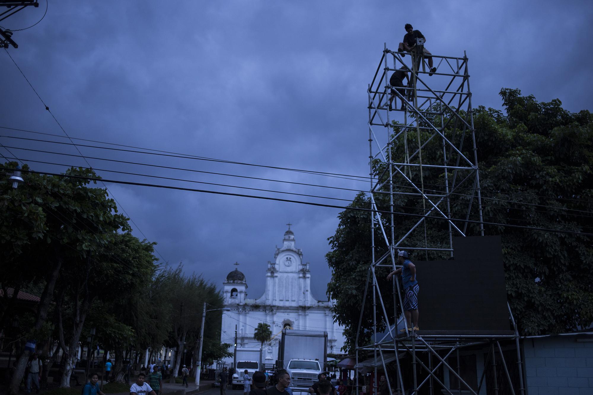 Técnicos arman la tarima donde se realizaría la apertura de campaña del partido Arena, en el municipio de Izalco, departamento de Sonsonate. En horas de la noche del sábado, la atividad se suspendió. Foto: El Faro/ Víctor Peña