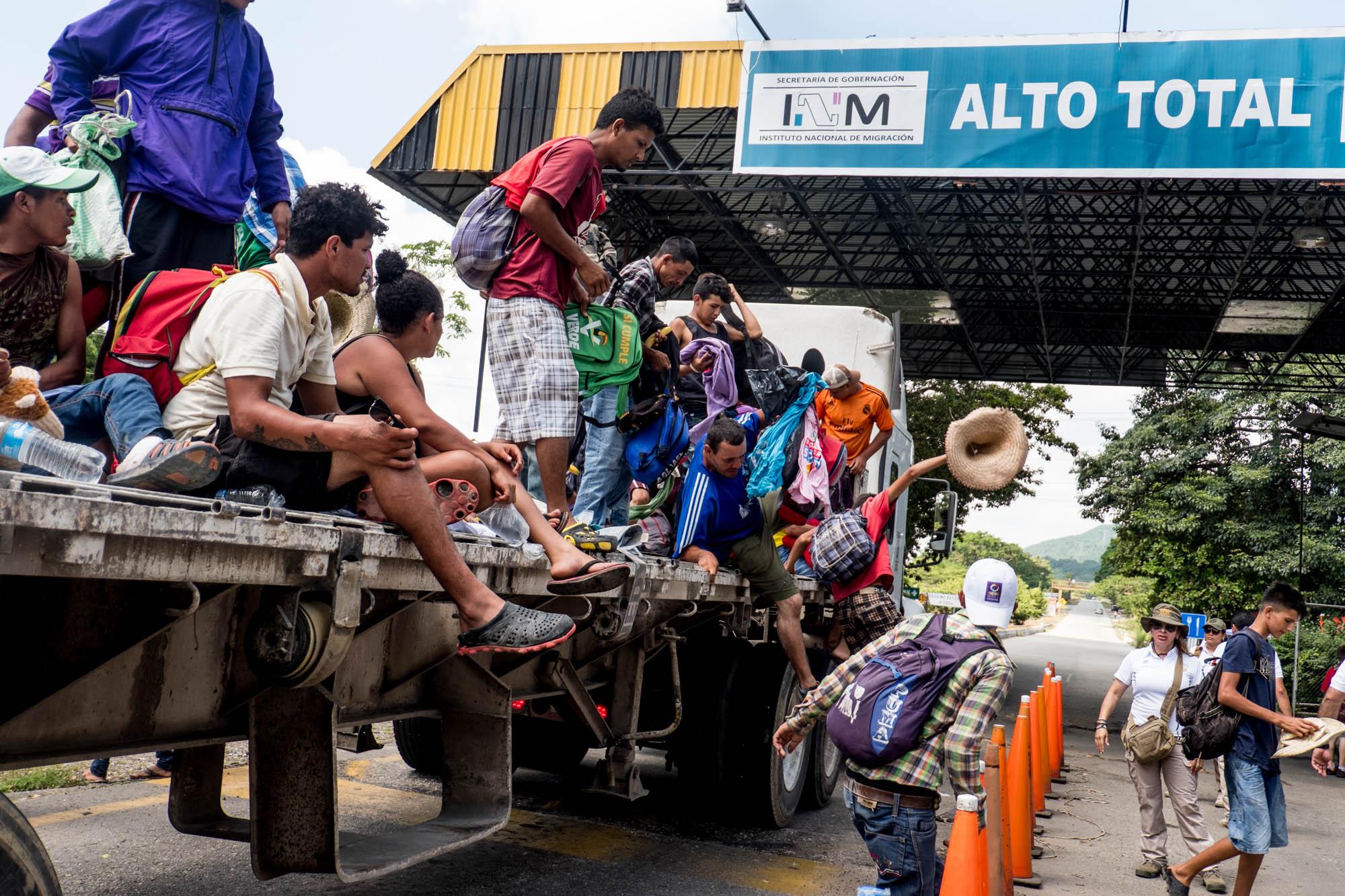 Caravana de migrantes hondureños, durante su paso por la garita migratoria de Pijijiapan, Chiapas, México, 24 de octubre de 2018, cuando eran bajados por un retén migratorio. Este grupo se separó del grueso de la columna de indocumentados, para intentar ahorrar caminata. Fueron detenidos en esto punto por agentes de Migración que solo los custodiaron hasta que la avalancha migrante de a pie alcanzó el lugar y los integró a la marcha. Foto de El Faro: Fred Ramos. 