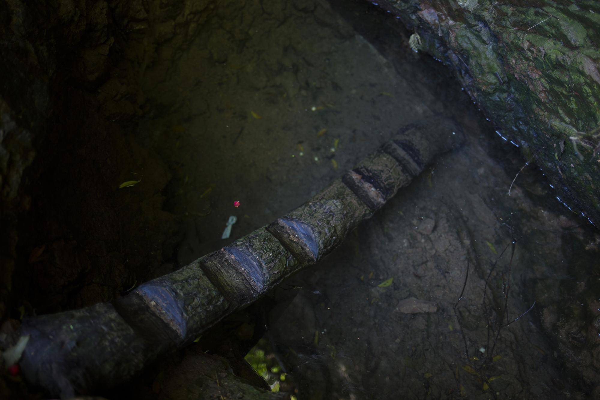 El caserío La Ceiba es un asentamiento aislado del cantón La Uvilla. Este nacimiento abastece a sus pobladores. El agua para beber, que extraen de este hoyo de dos metros de profundidad, contiene residuos de jabón, con el que lavan ropa. Para poder llenar un recipiente, antes deben ensuciar el agua con los pies que pisan la escalera improvisada con un tronco.