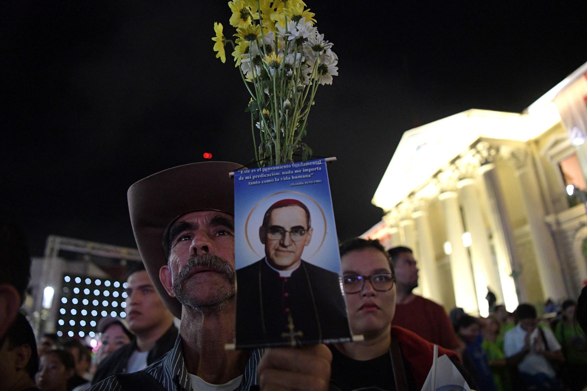 Retrato del santo en mano, un feligrés espera en la madrugada del 14 de octubre la canonización de monseñor Óscar Arnulfo Romero, en la ceremonia que tuvo lugar en la plaza Gerardo Barrios de San Salvador. Foto Marvin Recinos (AFP).