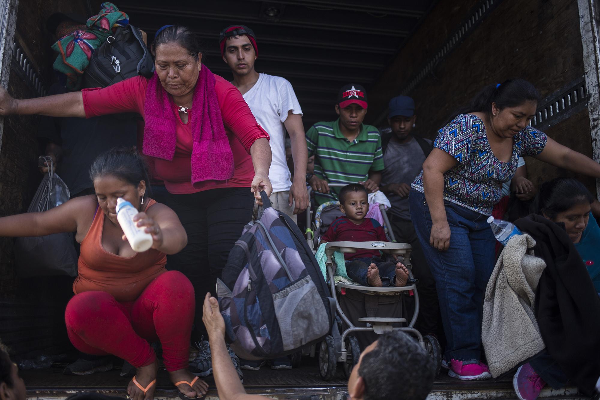 Fátima y su familia se bajan de un furgón, en el desvío del municipio de Arriaga y Tuxtla Gutiérrez, en el estado de Chiapas. Fátima recorre desde El Salvador junto a su esposo y sus tres hijos. Ellos viajana en la caravana que pretende llegar a Estados Unidos. Foto: Víctor Peña.