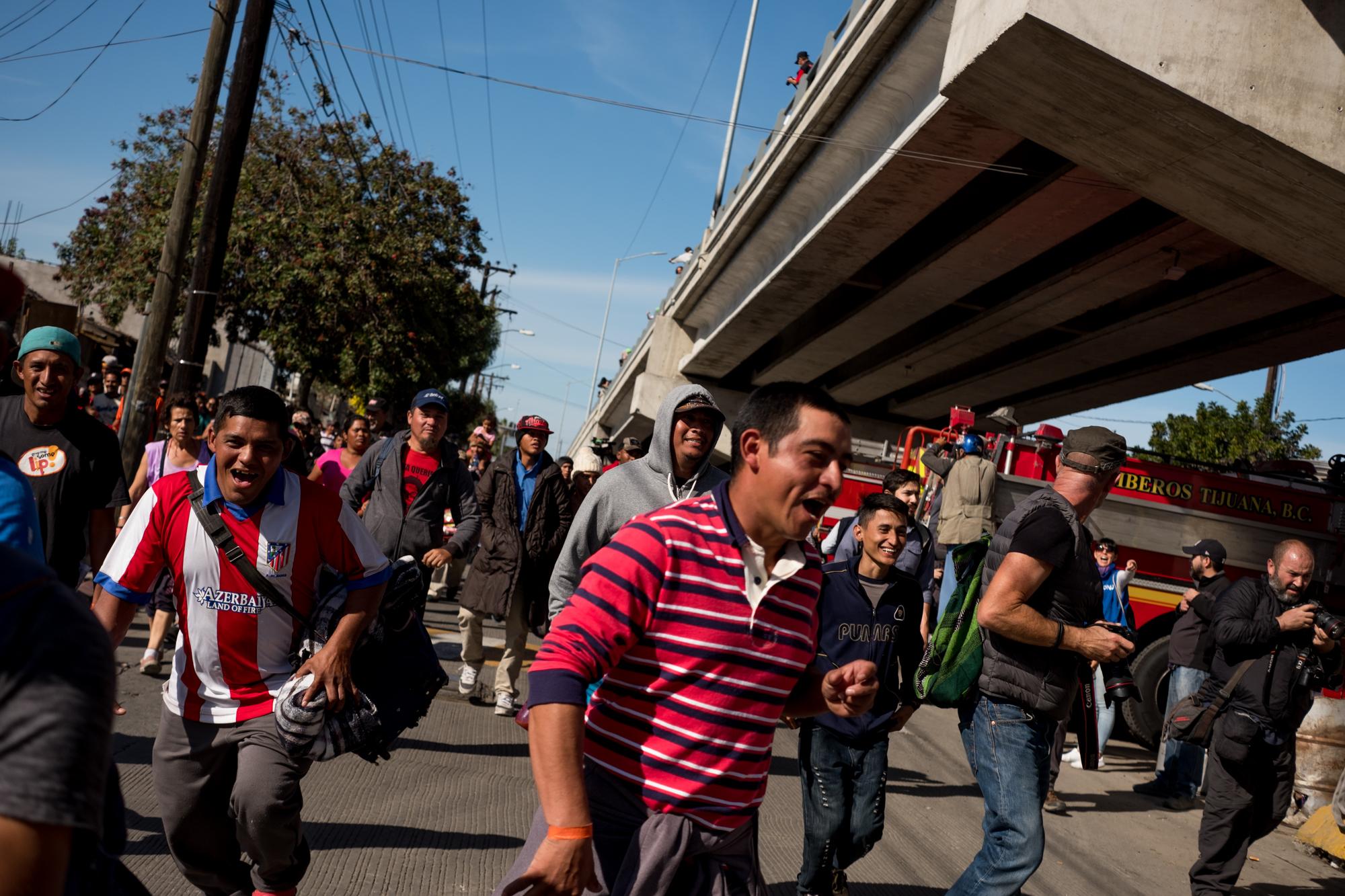 Migrantes centroamericanos corren en dirección al punto fronterizo El Chaparral, el domingo 25 de noviembre. Foto: Fred Ramos