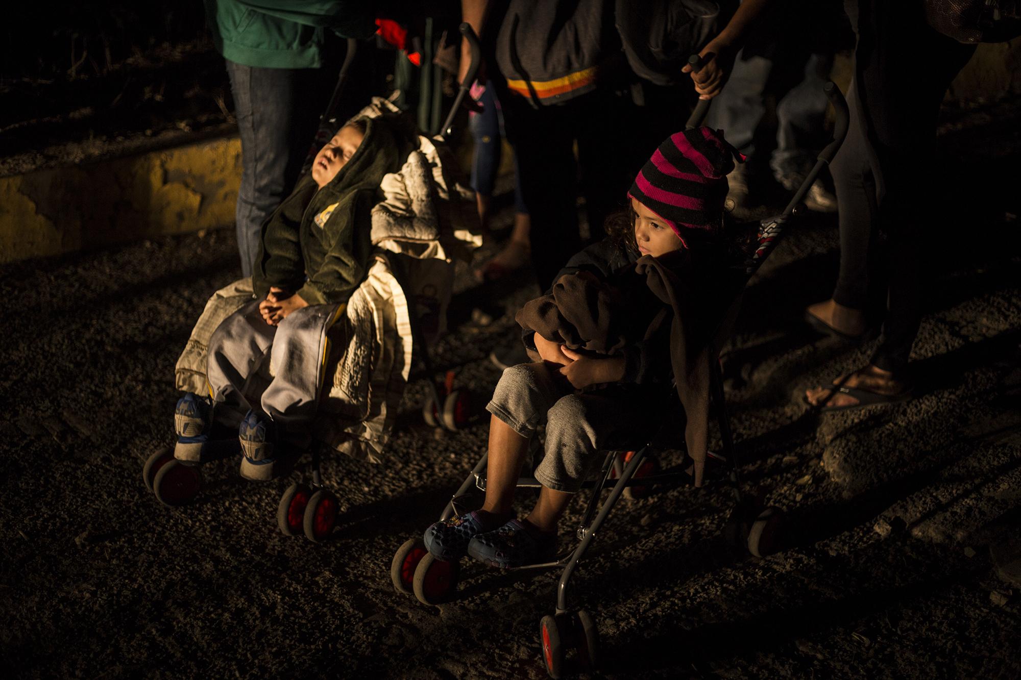 Una familia hondureña empuja dos carriolas con bebés ya del lado mexicano, tras pasar el puente fronterizo Rodolfo Robles, la madrugada del viernes 18 de enero. Eran los últimos de los más de 2,000 migrantes que cruzaron el portón sin esperar el proceso ofrecido por el gobierno mexicano. Cuando la mayoría pasó, las autoridades cerraron el portón. Los migrantes en la imagen eran los últimos. Al ver el portón cerrado, buscaron otro acceso, donde cruzaron frente a la mirada de las autoridades del INM, sin ninguna oposición. 