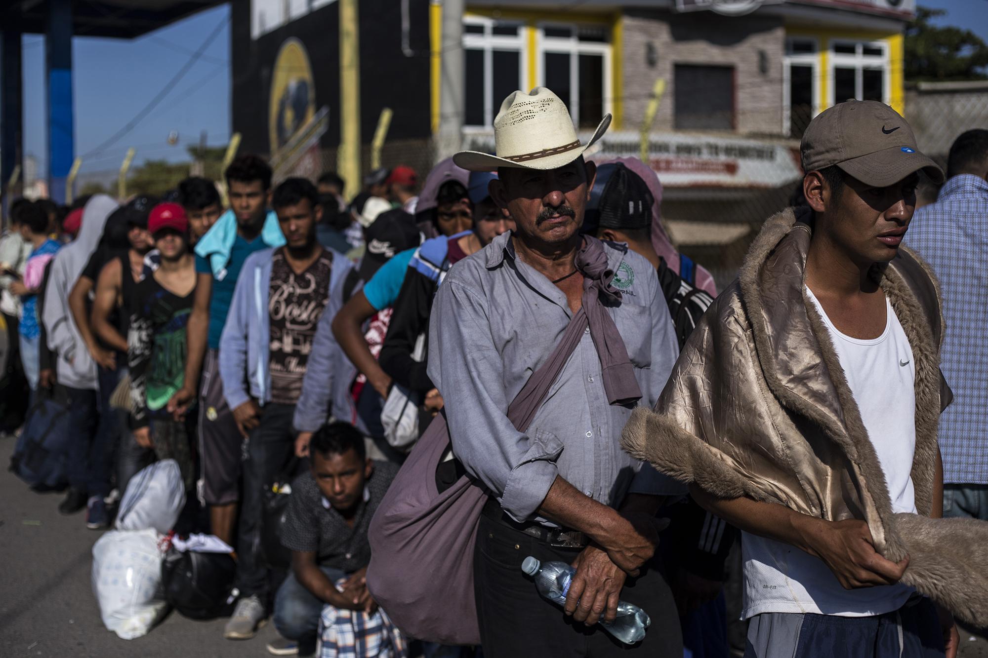 Migrantes centroamericanos esperan para hacer miración, en la aduna Tecún Umán, en el municipio de Ayutla, Guatemala, el sábado 19 de enero. Los centroamericanos llegan por goteo a la frontera con México para obetener un permiso que les permita trabajar y transitar por un año en México. Foto: Víctor Peña.