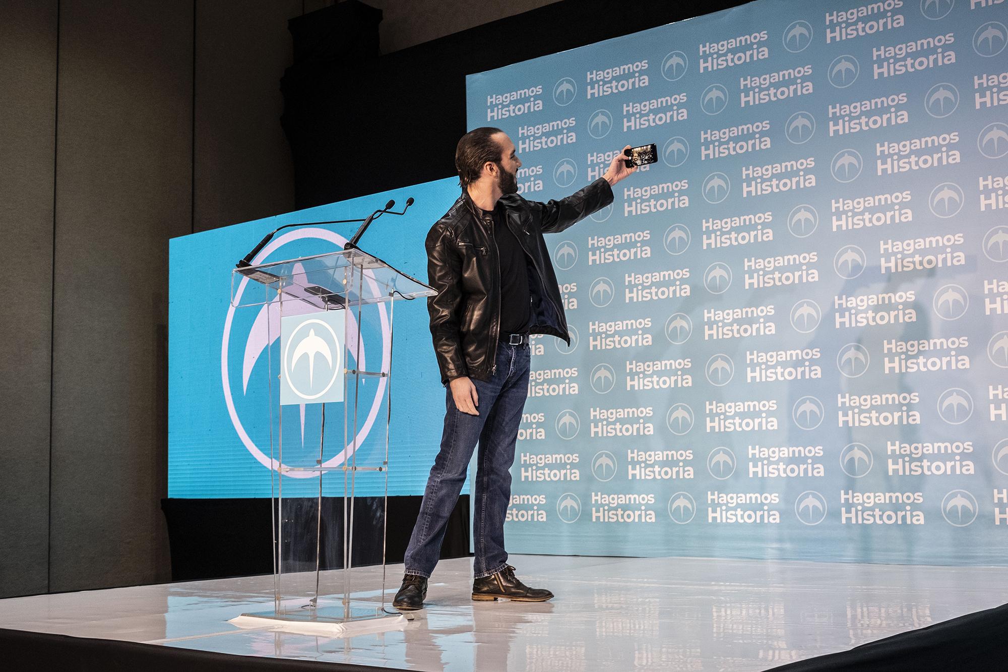 Nayib Bukele se toma una selfie frente a los periodistas, observadores y personas cercanas a su círculo, durante la conferencia de prensa en donde se proclamó ganador de las elecciones presidenciales a las 9:30 de la noche del 3 de febrero. Bukele rompió con el predominio histórico de las dos fuerzas políticas que ocuparon el Ejecutivo desde 1989, tres años antes de que terminara la guerra civil salvadoreña.  El derechista Arena quedó en un distante segundo lugar, con poco más de la mitad de los votos obtenidos por Bukele. Pero el gran perdedor de los comicios fue el FMLN que, luego de una década en el poder, obtuvo la menor cantidad de respaldos de toda su historia como partido político: menos de un 14%. Foto: Fred Ramos.