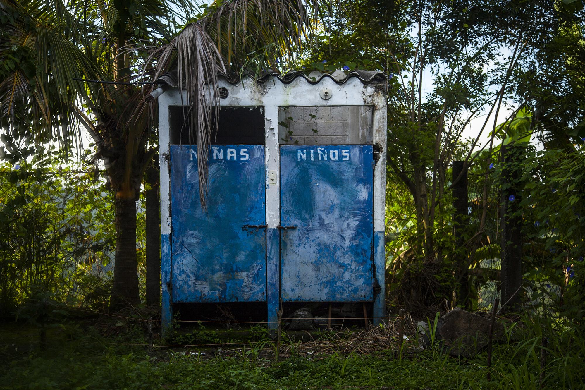 Servicios sanitarios en medio de la maleza, para el uso de los estudiantes del Centro Escolar Caserío Las Anonas, en el cantón Tijeretas, en el municipio de Torola, del departamento de Morazán. Nayib Bukele, presidente electo, ha solicitado a la Asamblea Legislativa que, del préstamo de 32 millones de dólares para la construcción del nuevo edificio del Órgano Legislativo se utilicen 16 millones para la construcción de 50 escuelas. 20 de octubre de 20717. Foto: Víctor Peña.