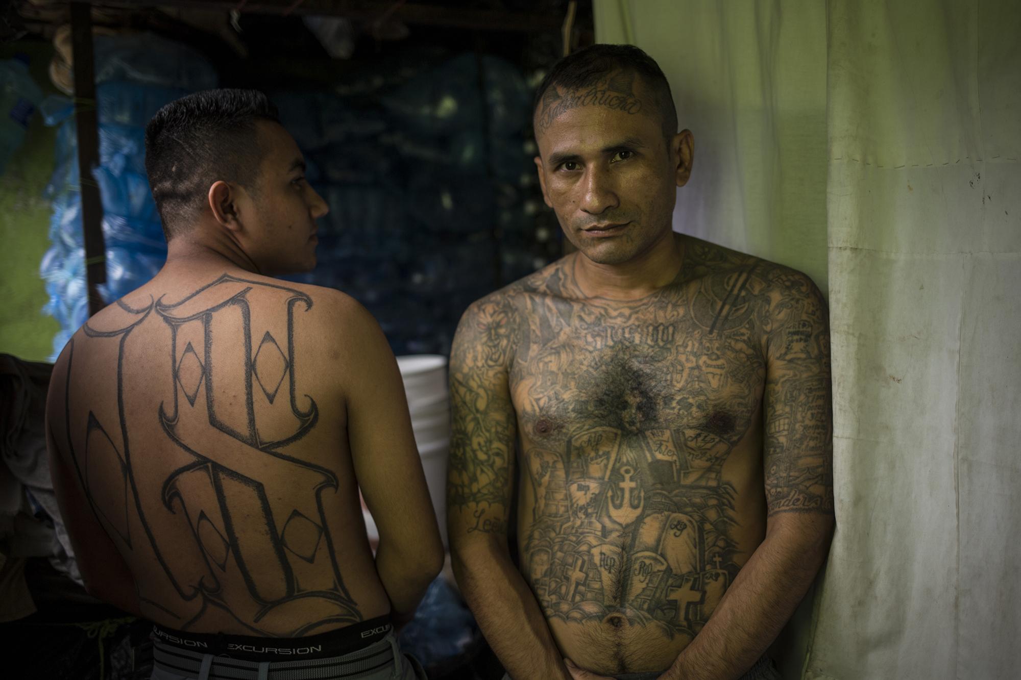 Moisés Ulises Alemán, de 22 años (izquierda), exmiembro del Barrio 18 Revolucionarios, del municipio de Aguilares. Moisés cumple una condena de 40 años por el delito de homicidio agravado. A su lado está Manfredy Salgado, de 36 años, exmiembro de la MS-13, de la colonia Panamericana, en la ciudad de San Miguel. Manfredy cumple una condena de 23 años por el delito de homicidio simple y portación de armas de guerra. En una bodega del sector número cinco donde conviven, Manfredy dice: 