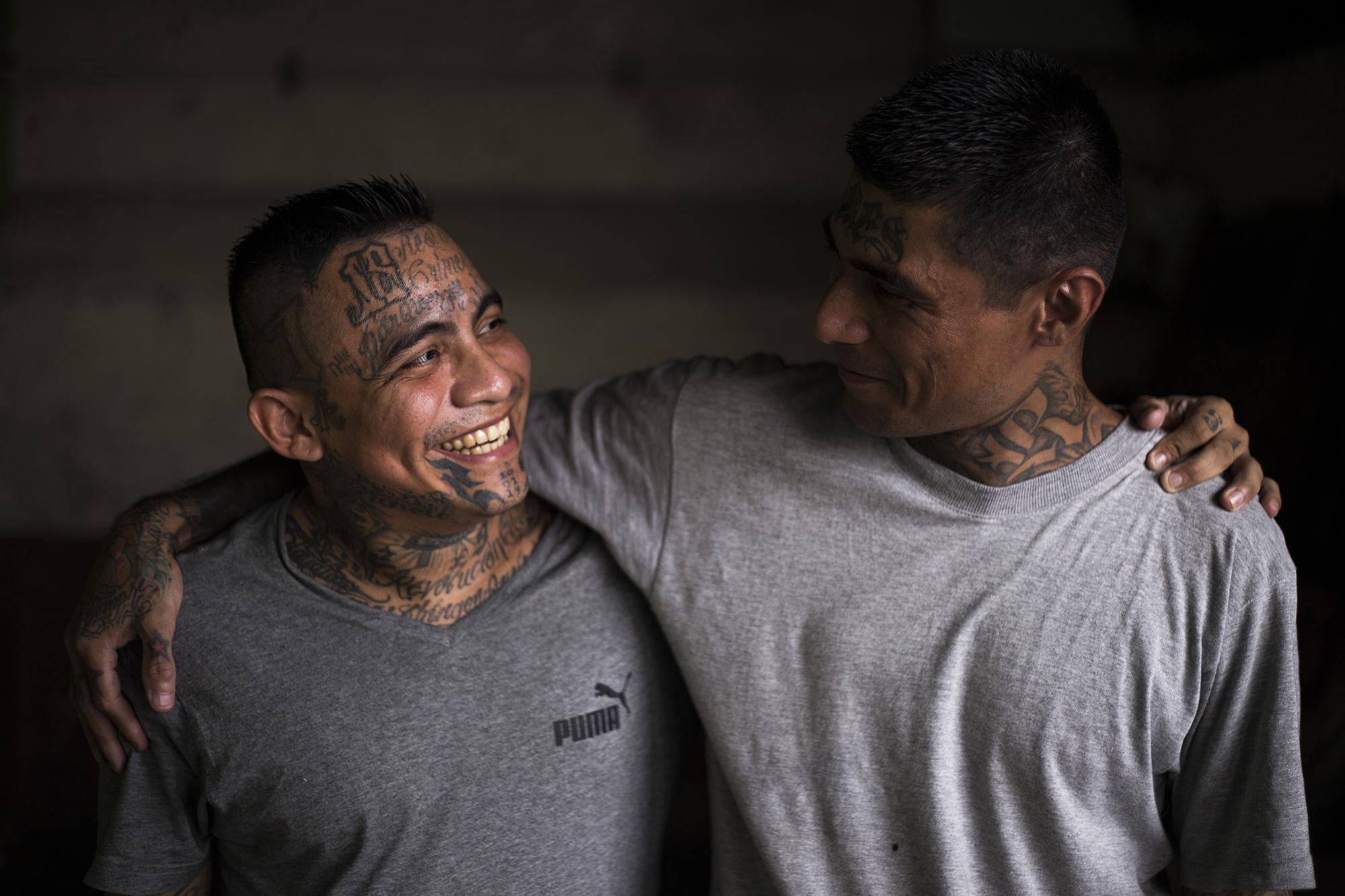 Cerca de los baños del sector seis, Remberto Colindres (izquierda) y Jorge Solito conversan. Ante la cámara, decidieron abrazarse. Dos meses atrás se conocieron en medio de las alabanzas a Dios dentro del penal. Remberto perteneció al Barrio 18 Revolucionarios del centro de San Salvador. Cumple una pena de cuatro años por tenencia ilegal de arma de fuego. Jorge lleva 14 años en prisión, y cumple una pena de 60. Asesinó cuando fue miembro de la MS 13 del municipio de Atiquizaya, en el departamento de Ahuachapán. 