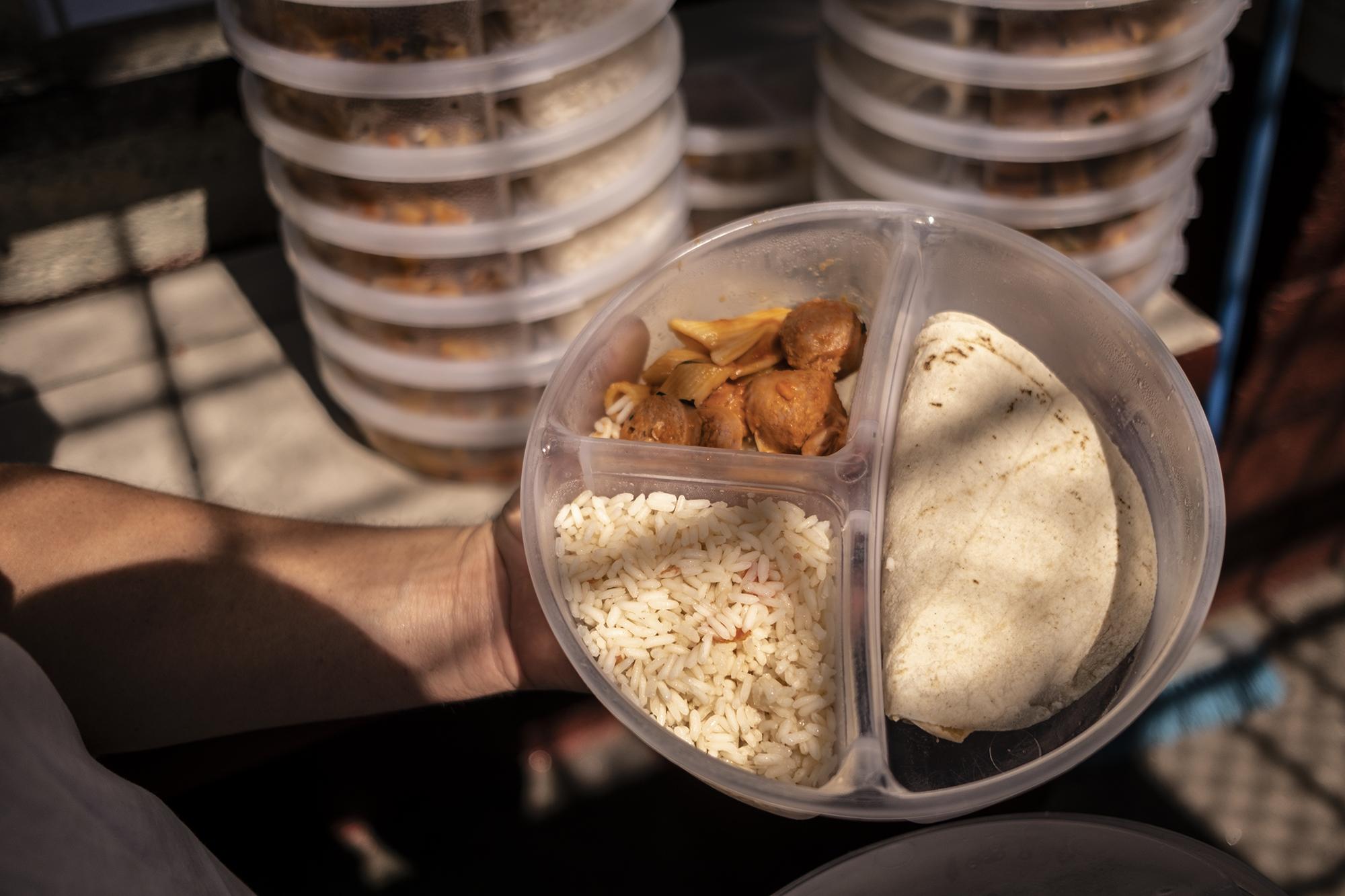 Puntual, cada día el almuerzo empieza a entregarse a las 12 del mediodía en Mariona. Una de las raciones servidas el jueves 31 de enero del 2019 fue un revuelto de salchicha con pasta, arroz y tortillas en un recipiente con tapadera para conservar la temperatura.