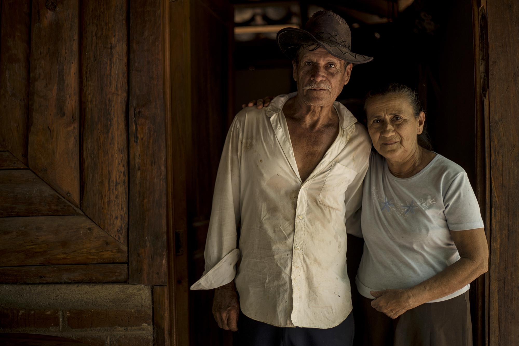 Antonia Tobar Márquez, de 66 años y Marcos Romero Argueta, de 70. Estos esposos fueron desplazados del caserío Jocote Amarillo, cercano a El Mozote, días antes de la masacre. Huyeron con sus cuatro hijos hacia el Valle de Zapotitán, en el departamento de La Libertad. Después de la firma de los Acuerdos de Paz volvieron y encontraron su casa convertida en escombros y envuelta por la maleza. Foto: Víctor Peña.