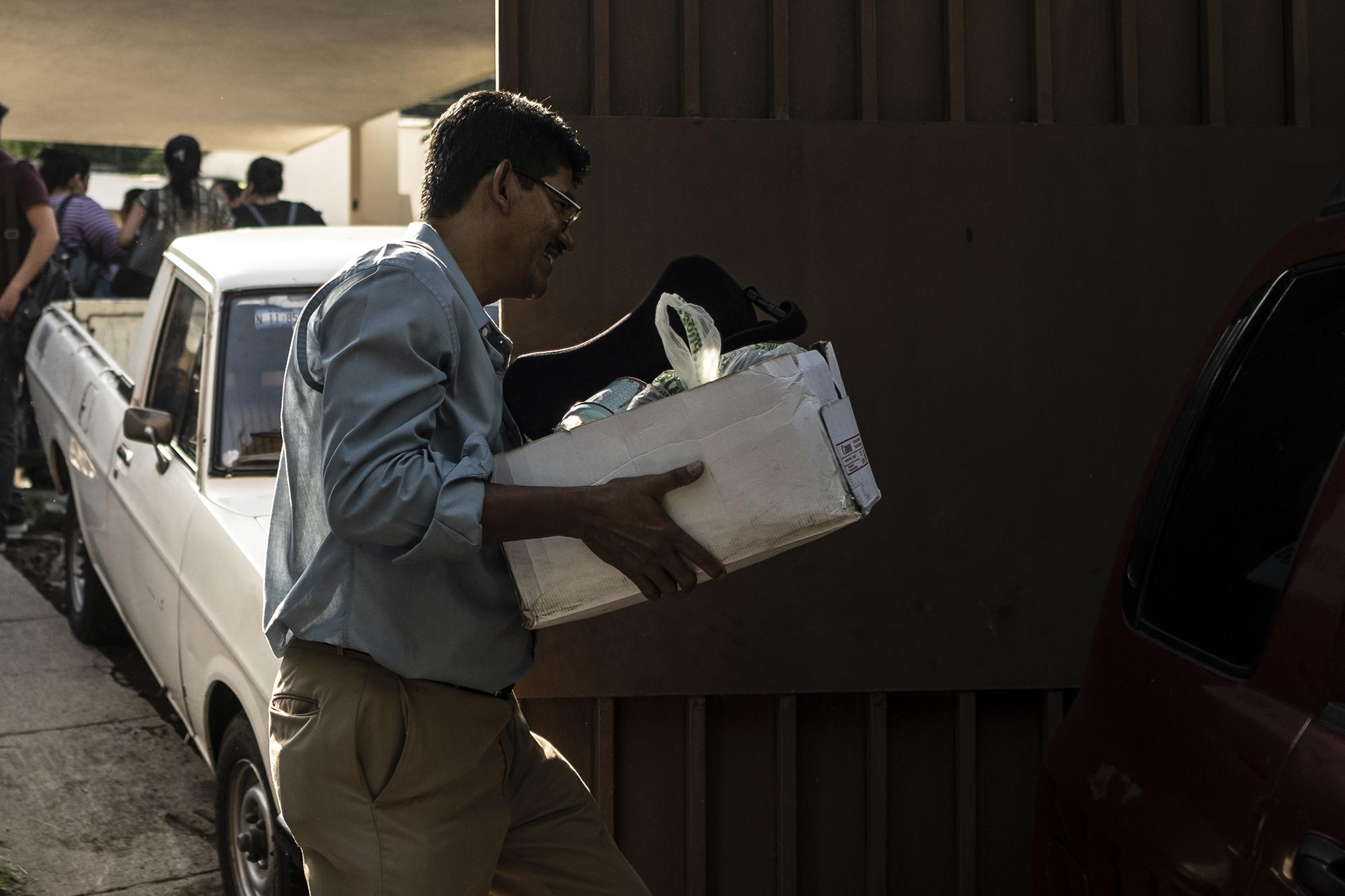 Un empleado de la Secretaría de Inclusión Social carga sus pertenencias después de ser informado de que su plaza dejaría de existir. Junio de 2019. Foto: Archivo / El Faro