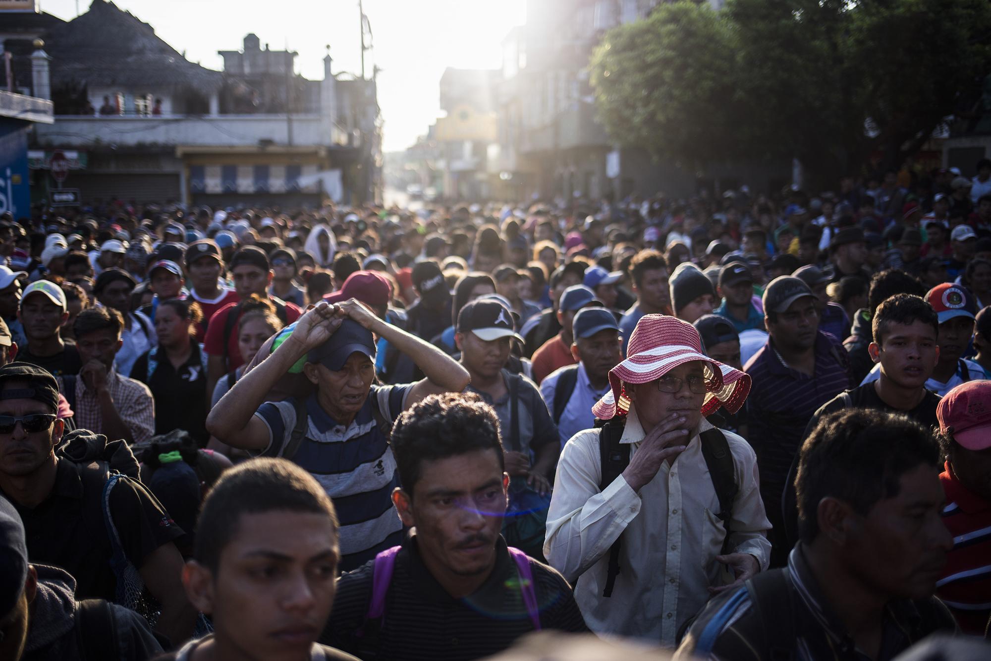 Una caravana de migrantes espera frente al portón de la aduana guatemalteca, en el paso de la frontera Tecún Umán. Más de 2 mil personas, procedentes de los países del Triángulo Norte de Centroamérica, llegaron a este lugar para cruzar a México y caminar hacia Estados Unidos. Foto: Víctor Peña.