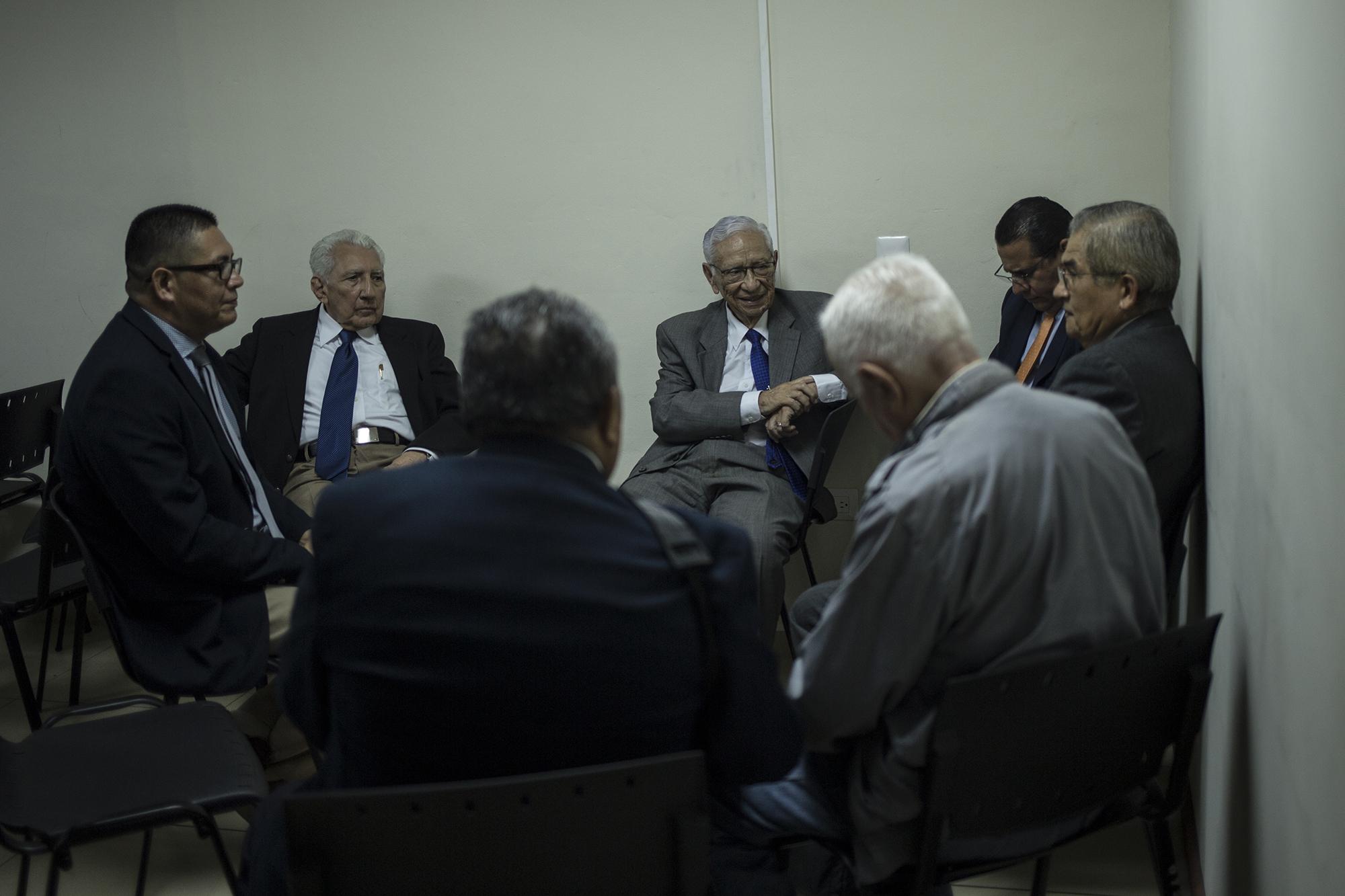 Cuatro de los militares acusados por la masacre de El Mozote conversan con sus abogados tras la audiencia de intimación este 18 de julio de 2019. Foto: Víctor Peña.