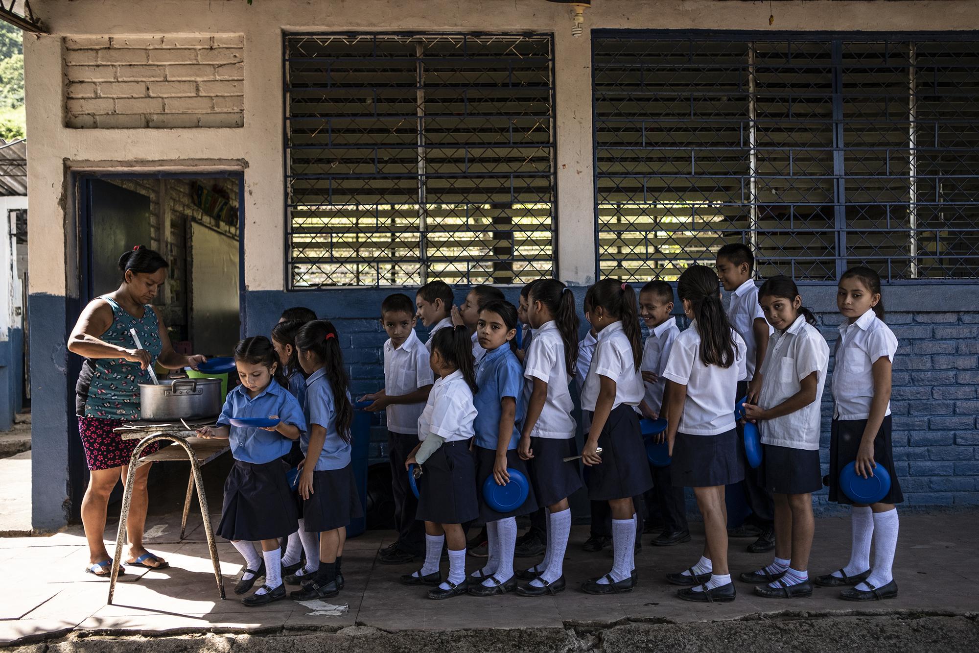 Estudiantes del Centro Escolar Caserío El Tule, en el Cantón El Pinalón, Santa Ana reciben raciones de comida entregada a través del programa de alimentación escolar del Gobierno. Foto, Carlos Barrera. 