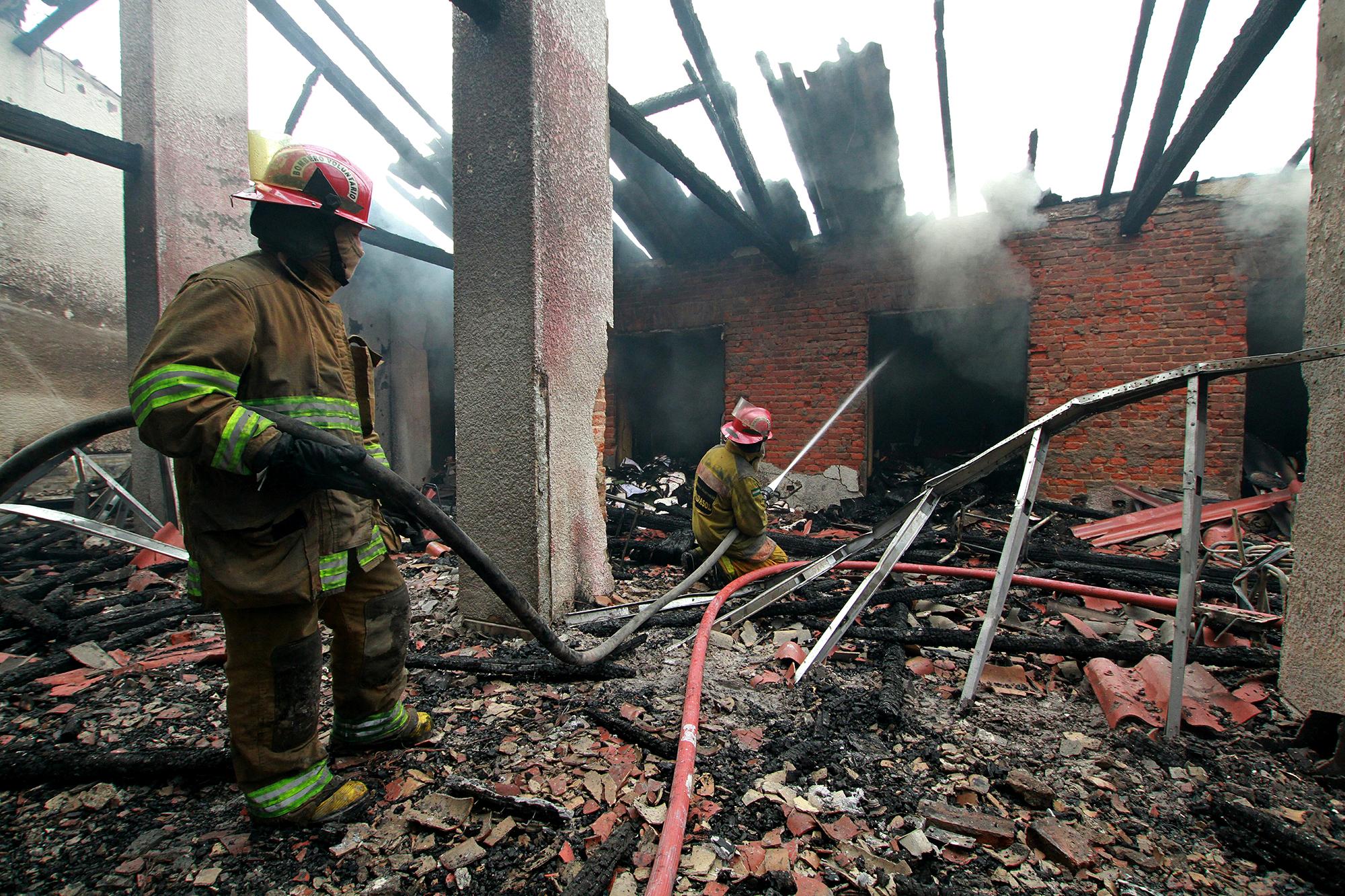 Bomberos extinguen un incendio provocado en el Tribunal Electoral Departamental durante las protestas tras los resultados electorales, en Santa Cruz, Bolivia, el 23 de octubre de 2019. Foto por Daniel Walker / AFP.