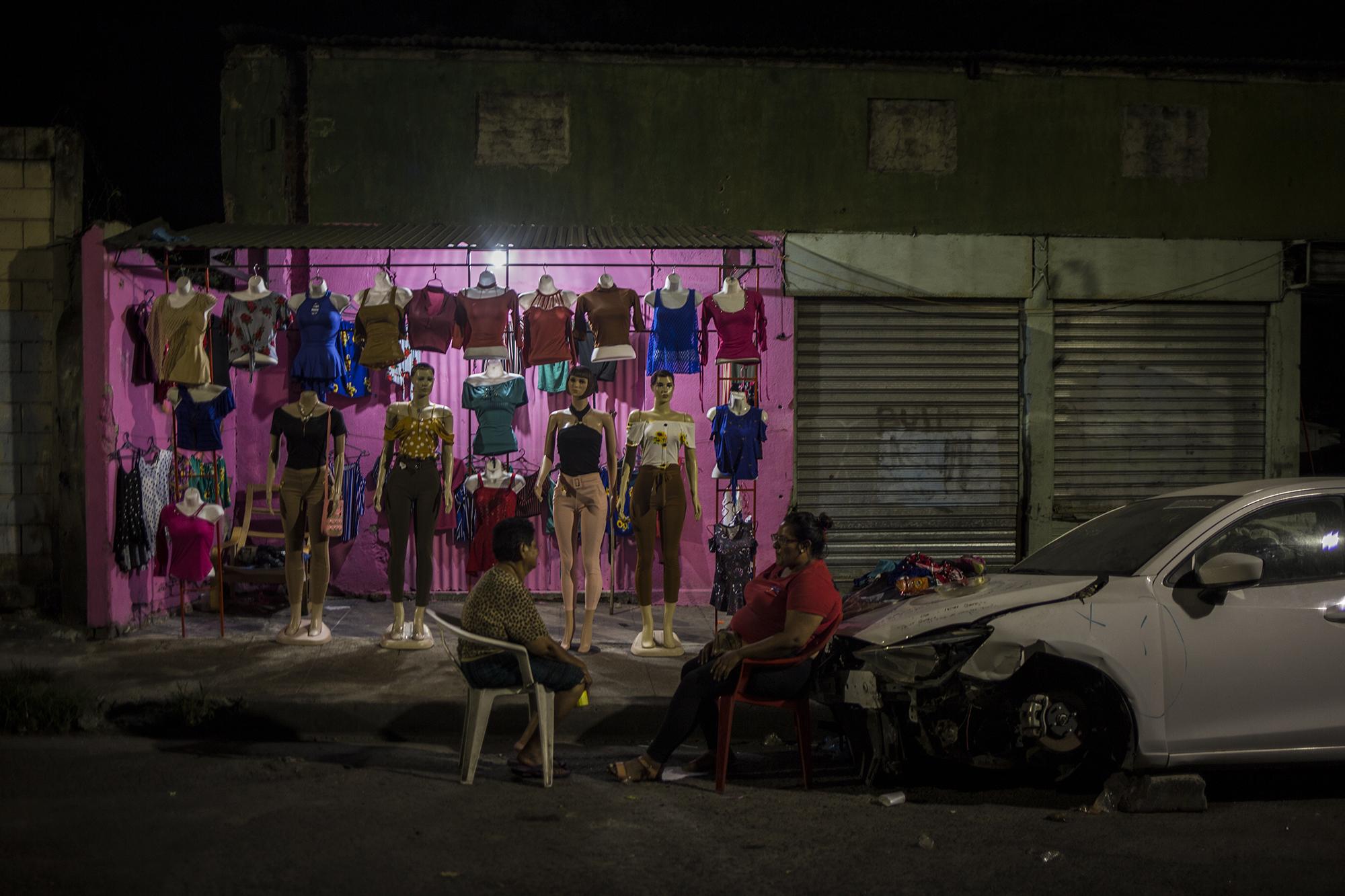 Eran las 11:30 de la noche del sábado en las calles recónditas del Centro de San Salvador. Hay un negocio abierto. Una venta de ropa que, por la poca afluencia de gente, permaneció abierto el sábado 14 de marzo. María Marta Rosales, de 65 años, y Mónica Marconi, de 34, conversaban con la esperanza de tener un cliente a esa hora sobre la 5 Calle Oriente, y llevar algo de dinero a casa.