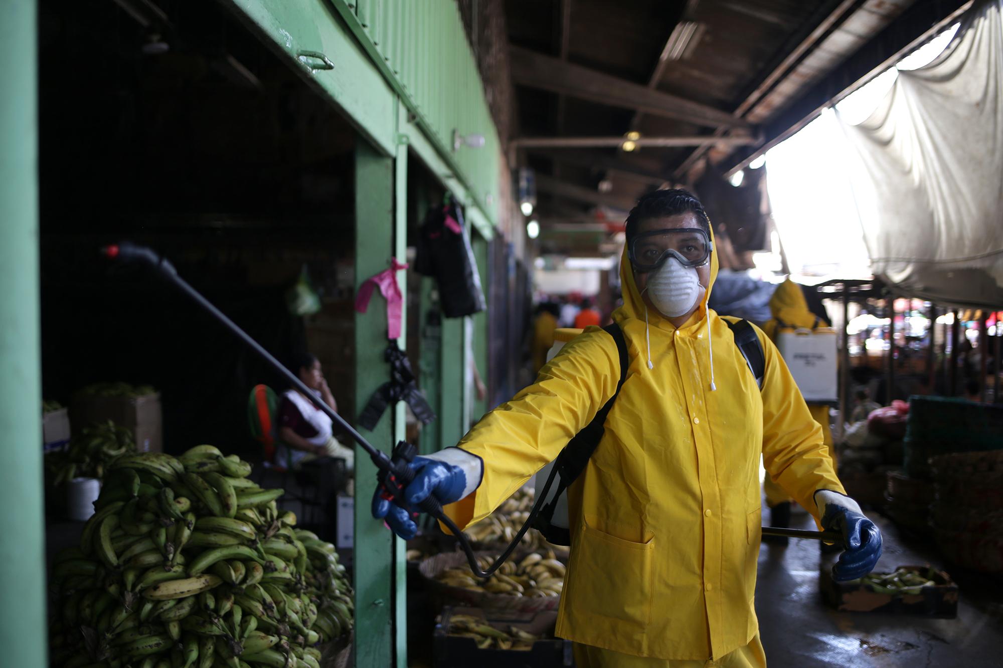 Los trabajadores del gobierno de San Salvador limpian el mercado de Tiendona, la central de abastos de frutas y verduras de San Salvador. Foto de El Faro: Víctor Peña.