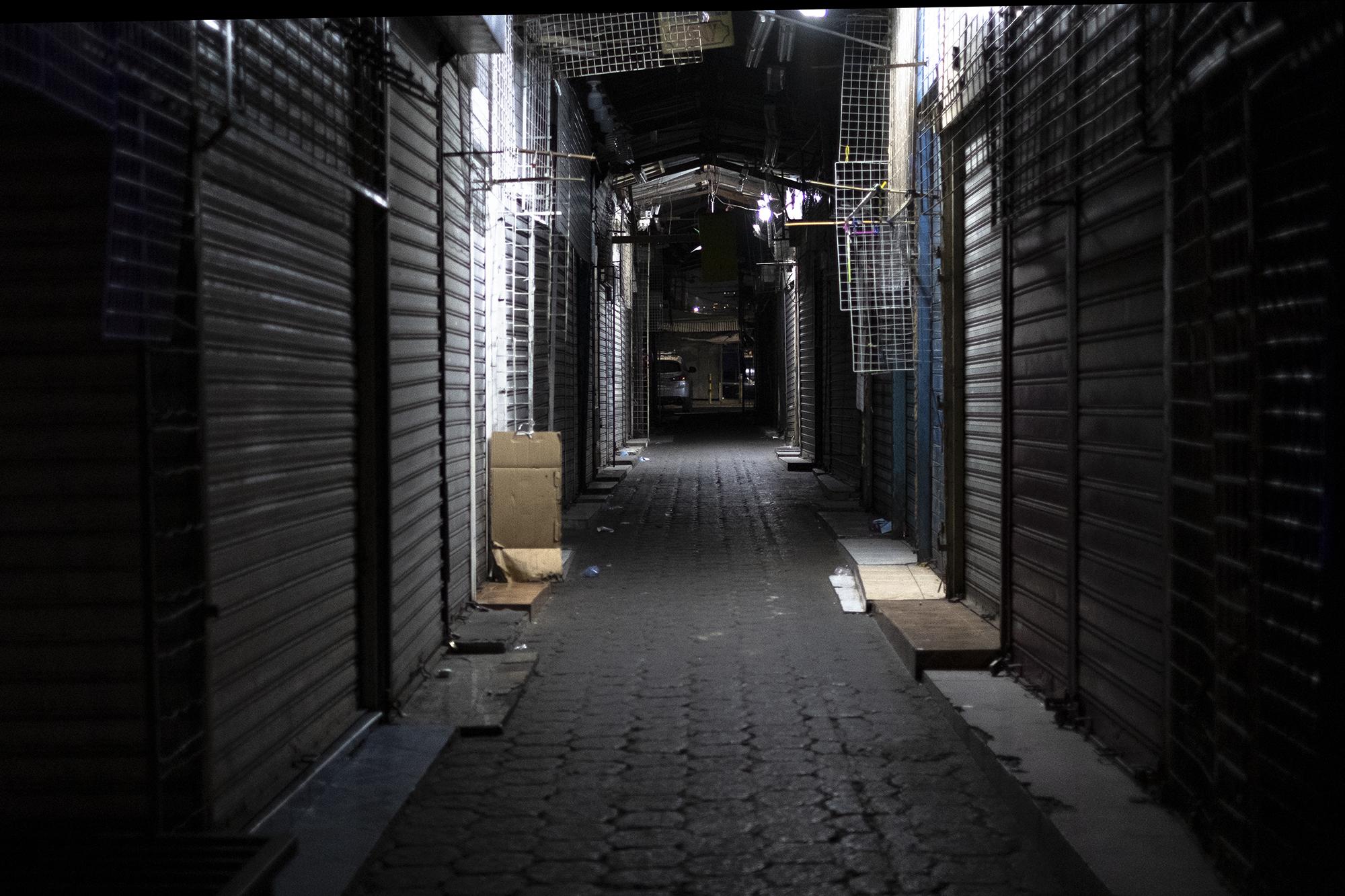 Así lucía la calle Arce a las 7:00 de la noche del sábado 21 de marzo. Todos los negocios, en su mayoría venta de ropa, estaban cerrados. Normalmente la calle está abarrotada por las personas que transitan y los que permanecen en sus negocios. Foto de El Faro: Carlos Barrera 